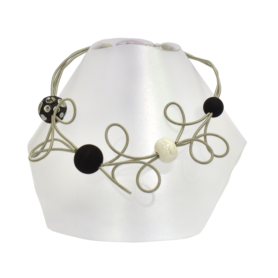 Collier ROSE DES SABLES, no 141, de l'artiste Sandrine Giraud, couleur gris argent, perles blanche et noire. Ce bijou marie avec élégance la grâce et l’originalité des lignes.