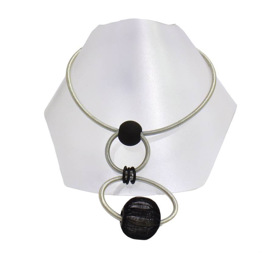Collier RESSORT DOUBLE ANNEAUX, no 128, de l'artiste Sandrine Giraud, couleur gris argent, noir. Ce bijou marie avec élégance la grâce avec l’originalité des lignes.
