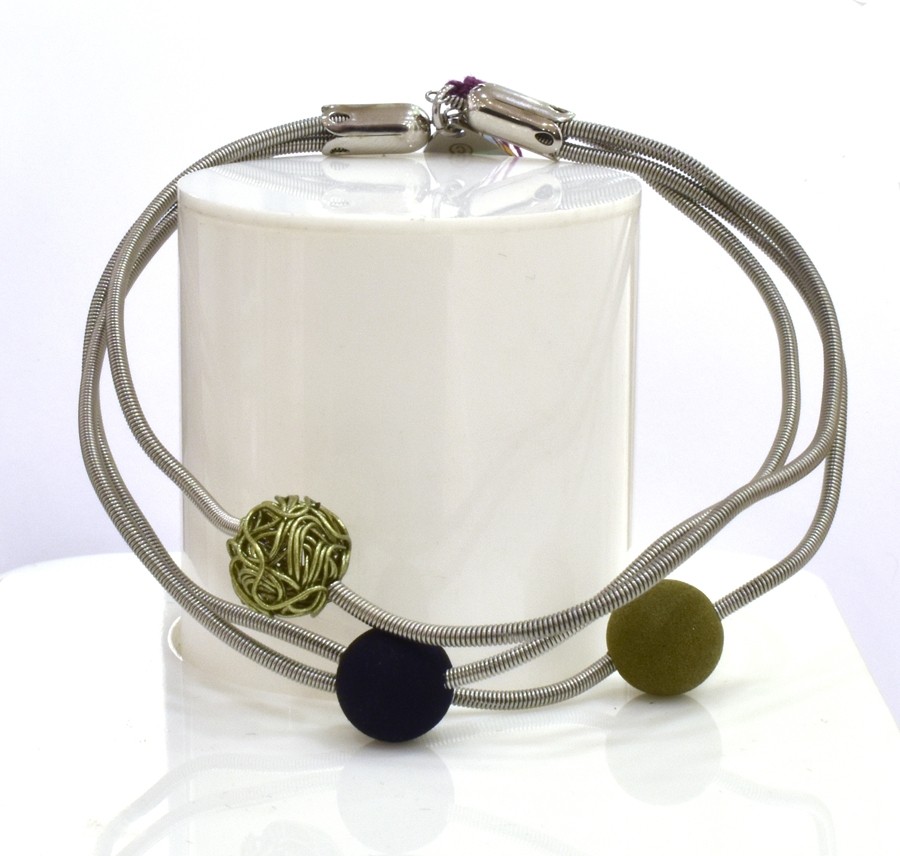 Bracelet SATELLITE FIN, no 72, de l'artiste Sandrine Giraud. Couleur gris argent et perles olive et noire. Ce bijou marie avec élégance la grâce et l’originalité des lignes.