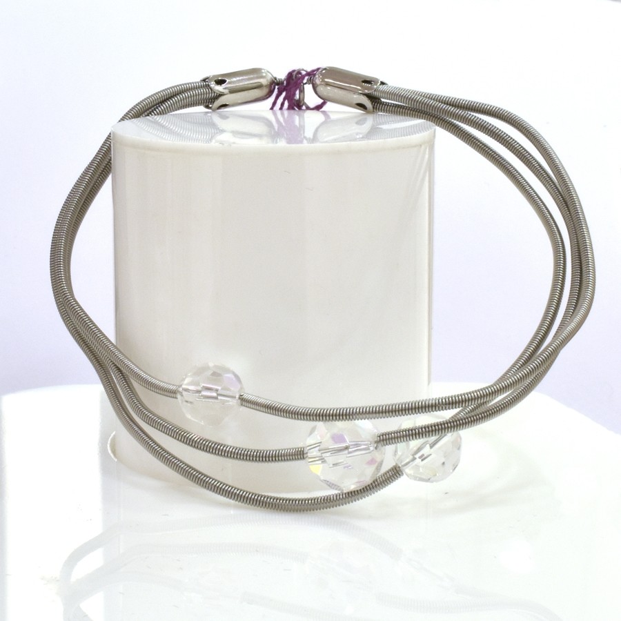 Bracelet SATELLITE FIN, no 76, de l'artiste Sandrine Giraud. Couleur gris argent et perles transparentes. Ce bijou marie avec élégance la grâce et l’originalité des lignes.