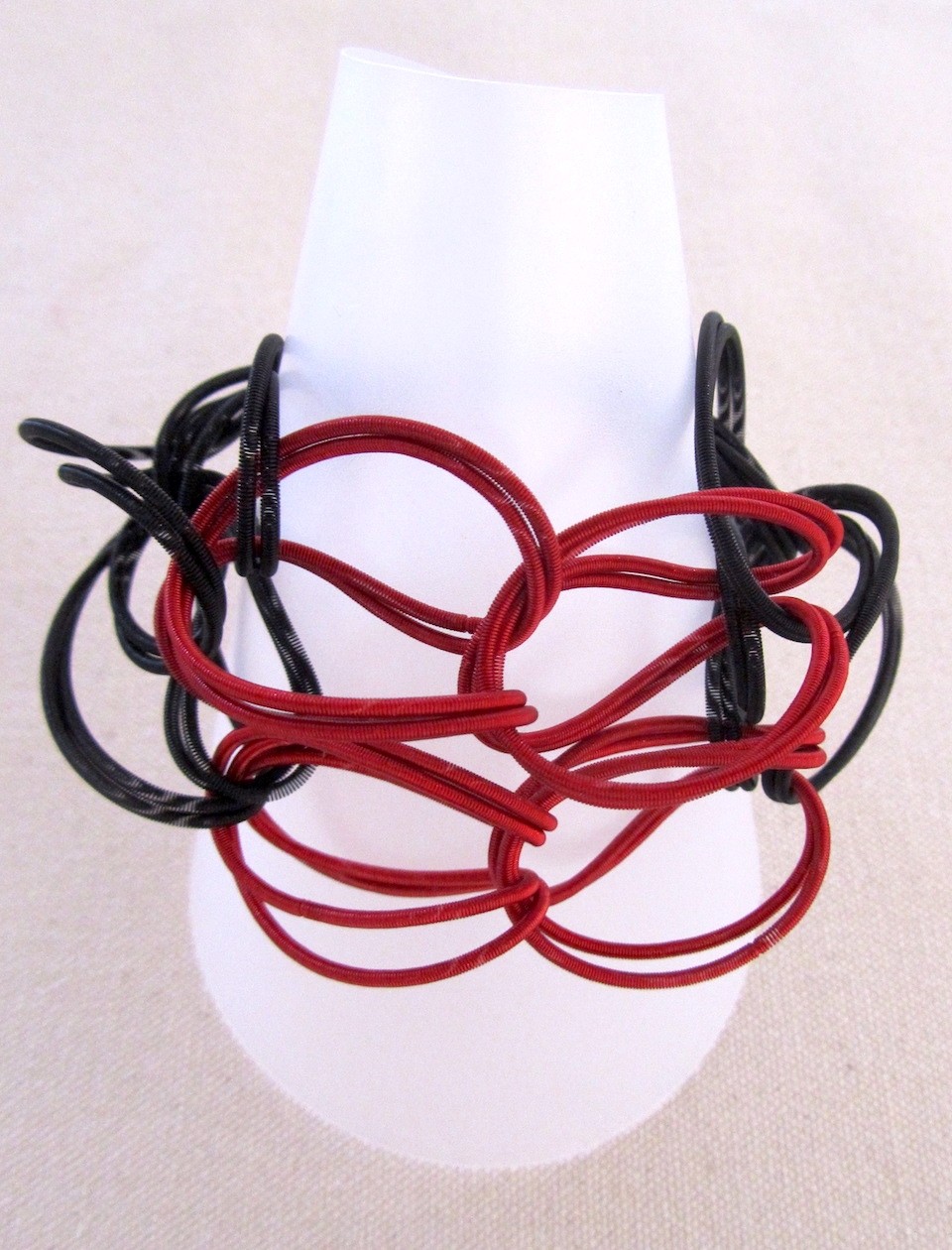 Bracelet TWIST noir et rouge, no 65, de l'artiste Sandrine Giraud, Ce bijou marie avec élégance la grâce et l’originalité des lignes résolument contemporaines.