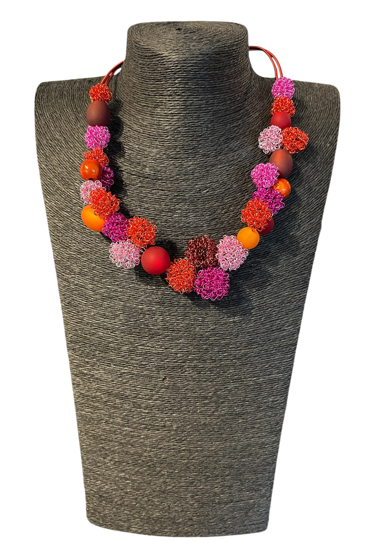 Collier ESCARGOT FLOCON, no 175, de l'artiste Sandrine Giraud, couleur, rose, rouge, orange. Ce bijou toujours original, marie avec élégance la grâce et l’originalité des lignes.