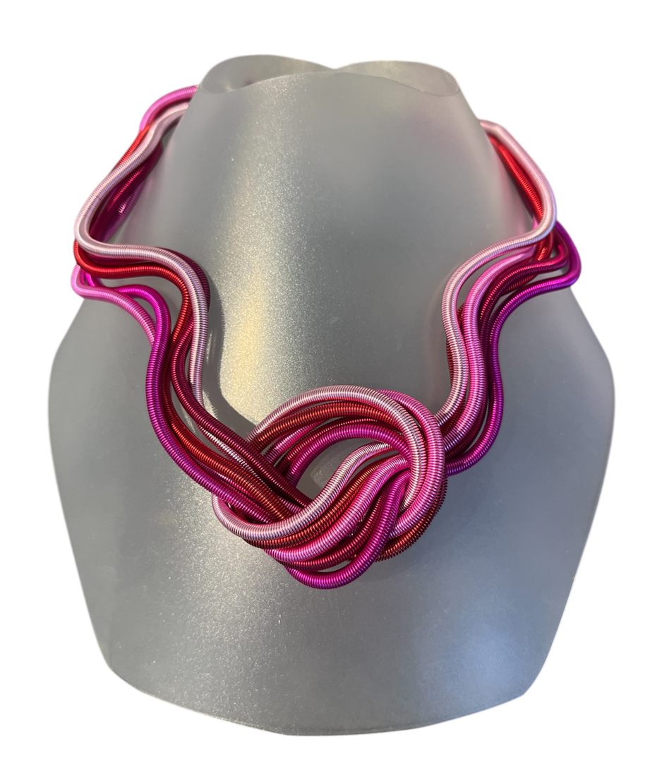 Collier MÉLI MÉLO, no 190, de l'artiste Sandrine Giraud, couleur, rose et rouge. Ce bijou modulable, toujours original, marie avec élégance la grâce et l’originalité des lignes.