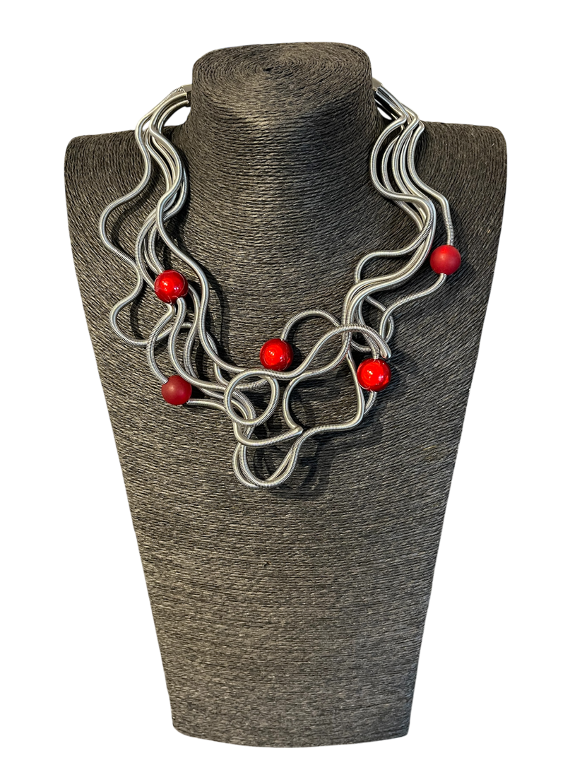 Collier RC-CERTI, no 187, de l'artiste Sandrine Giraud, couleur, argent, perles rouges. Ce bijou modulable, toujours original, marie avec élégance la grâce et l’originalité des lignes.