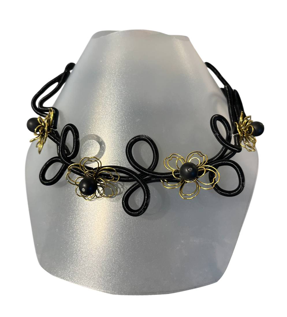 Collier ROSE FLEUR, no 92, de l'artiste Sandrine Giraud, couleur, noir, fleurs or et perles noires. Ce bijou modulable, toujours original, marie avec élégance la grâce et l’originalité des lignes.