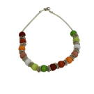 Collier POLARIS, no 151, de l'artiste Sandrine Giraud, couleur, argent et perles : rouge, grenat et verte. Ce bijou, toujours original, marie avec élégance la grâce et l’originalité des lignes.