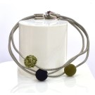 Bracelet SATELLITE FIN, no 72, de l'artiste Sandrine Giraud. Couleur gris argent et perles olive et noire. Ce bijou marie avec élégance la grâce et l’originalité des lignes.