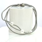 Bracelet SATELLITE FIN, no 75, de l'artiste Sandrine Giraud. Couleur gris argent et perles blanches. Ce bijou marie avec élégance la grâce et l’originalité des lignes.