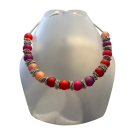 Collier POLARIS, no 154, de l'artiste Sandrine Giraud, couleur, argent, perles roses, rouges, oranges. Ce bijou toujours original, marie avec élégance la grâce et l’originalité des lignes.