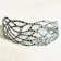 Bracelet Entrelac (gris argent, pois noirs), no 17, de l'artiste Molusk, Longueur 6.5 pouces, Bijou aquatique souple et léger fait de PVC coloré qui épouse la forme du corps à la manière d’un tatouage, vue 2